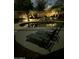 Night view of backyard pool with rock feature, lounge chairs, and elegant lighting at 462 S Marie Dr, Chandler, AZ 85225
