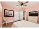 Cozy bedroom with light pink walls, ceiling fan, wood floors, and a stylish dresser with TV at 5605 N 19Th St, Phoenix, AZ 85016