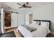 Cozy bedroom with wood-look floors, ceiling fan, closet and sliding barn door to the bathroom at 5605 N 19Th St, Phoenix, AZ 85016
