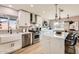 Bright, remodeled kitchen featuring white cabinetry, stainless appliances, and a waterfall island with bar seating at 5605 N 19Th St, Phoenix, AZ 85016
