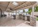 Covered outdoor kitchen with stone accents, built-in grill, stainless steel fridge, and bar seating at 5605 N 19Th St, Phoenix, AZ 85016