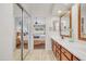 Bright bathroom with dual sinks, beautiful wood cabinets, and a view into the primary bedroom at 5830 E Mckellips Rd # 30, Mesa, AZ 85215