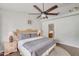 Bedroom featuring a bed with two lamps, ceiling fan, and view into the bathroom at 5830 E Mckellips Rd # 30, Mesa, AZ 85215