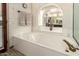 Luxurious tub nestled in a well-lit bathroom with a large mirror and modern decor at 6019 E Paradise Ln, Scottsdale, AZ 85254