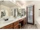 Bathroom featuring double sinks, warm lighting, and a door to the exterior at 6019 E Paradise Ln, Scottsdale, AZ 85254