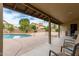 Inviting covered patio area with a view of the pool and landscaped backyard at 6019 E Paradise Ln, Scottsdale, AZ 85254