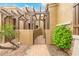 Exterior view of the courtyard showing a decorative gate, pergola, desert landscaping, and a brick-paved walkway at 6202 E Mckellips Rd # 189, Mesa, AZ 85215