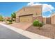 View of the two-car garage featuring a neutral stucco exterior, stone accents, a brick paver driveway, and manicured landscaping at 6202 E Mckellips Rd # 189, Mesa, AZ 85215