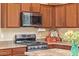A stainless steel gas range and microwave accent this kitchen with granite counters and natural wood cabinetry at 6202 E Mckellips Rd # 189, Mesa, AZ 85215