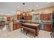 Spacious kitchen featuring an island with seating, granite countertops, stainless appliances, and natural wood cabinetry at 6202 E Mckellips Rd # 189, Mesa, AZ 85215