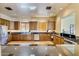 Open kitchen boasts stainless steel appliances, dark countertops, ample wood cabinetry, and modern lighting at 6202 E Mckellips Rd # 189, Mesa, AZ 85215