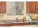 Close-up shot of the kitchen featuring stainless steel appliances, granite countertops, custom wood cabinets, and a window at 6202 E Mckellips Rd # 189, Mesa, AZ 85215