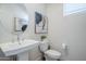 Powder room featuring pedestal sink, round mirror, toilet, artwork and window with natural light at 630 W Laredo St, Chandler, AZ 85225