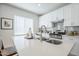 Bright kitchen has stainless steel appliances, white cabinets and countertops, and a kitchen island at 630 W Laredo St, Chandler, AZ 85225