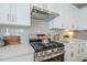 Close up of kitchen range with stainless steel appliances, white cabinets, and light tile backsplash at 630 W Laredo St, Chandler, AZ 85225
