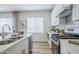Modern kitchen features stainless steel appliances, white cabinets, quartz counters, and wood-look flooring at 630 W Laredo St, Chandler, AZ 85225