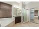 Primary bathroom features a soaking tub, a vanity sink, and a glass enclosed shower at 6528 W Via Montoya Dr, Glendale, AZ 85310