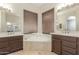 Bathroom featuring dual vanities, a soaking tub set beneath a window at 6528 W Via Montoya Dr, Glendale, AZ 85310