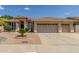Charming single-story home featuring a three-car garage, desert landscaping, and a welcoming entrance at 6528 W Via Montoya Dr, Glendale, AZ 85310