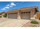 This desert home features a three-car garage, desert landscaping, and a tile roof at 6528 W Via Montoya Dr, Glendale, AZ 85310