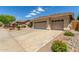 The exterior of this desert home features a three-car garage and drought-resistant landscaping at 6528 W Via Montoya Dr, Glendale, AZ 85310