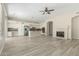 Open-concept living room and kitchen area with hardwood floors and a cozy fireplace at 6528 W Via Montoya Dr, Glendale, AZ 85310