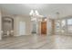Open living room featuring wood-look floors, a chandelier, arched entryways, and plentiful natural light at 6528 W Via Montoya Dr, Glendale, AZ 85310