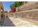 Outdoor kitchen and dining area with stone accents and blooming bougainvillea on retaining wall at 6528 W Via Montoya Dr, Glendale, AZ 85310