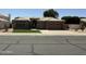 Charming single-story home featuring a tile roof, a three-car garage, and manicured front lawn at 6821 W Donald Dr, Glendale, AZ 85310