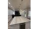 Open-concept kitchen island with quartz countertop and pendant lights, flows into the living space at 6821 W Donald Dr, Glendale, AZ 85310