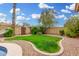 The backyard has a grassy area, small trees, and a path made of concrete, perfect for a relaxing outdoor experience at 7229 S Butte Ave, Tempe, AZ 85283