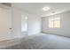 A bright bedroom with neutral carpet, white walls, and natural light from the window at 7531 W Odeum Ln, Phoenix, AZ 85043