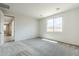 Bright bedroom with neutral carpet, a large window with natural light, and a view of the hallway at 7531 W Odeum Ln, Phoenix, AZ 85043