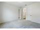 Spacious bedroom featuring neutral carpeting, white walls, and an en-suite bathroom at 7531 W Odeum Ln, Phoenix, AZ 85043