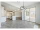 Open dining area with a stylish chandelier, sliding glass doors to the patio, and adjacent kitchen at 7531 W Odeum Ln, Phoenix, AZ 85043