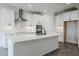 Modern kitchen features white cabinets, quartz countertops, stainless steel appliances, and an island at 7531 W Odeum Ln, Phoenix, AZ 85043