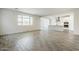 Spacious living room with gray wood-look tile flooring and a view of the kitchen at 7531 W Odeum Ln, Phoenix, AZ 85043