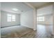 Bright living room with neutral carpet, large windows, and a view into another room at 7531 W Odeum Ln, Phoenix, AZ 85043
