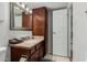 This bathroom features a vanity with a granite top, a mirror, and a white door at 7625 E Camelback Rd # B124, Scottsdale, AZ 85251
