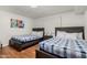 This bedroom boasts two beds, wooden floors, white walls, and plantation shutters at 7625 E Camelback Rd # B124, Scottsdale, AZ 85251