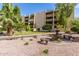 Beautifully landscaped condo complex with mature trees, plants, benches, a water feature, and walkways at 7625 E Camelback Rd # B124, Scottsdale, AZ 85251