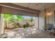 This spacious patio transitions to a yard with vegetation through a retractable metal door at 7625 E Camelback Rd # B124, Scottsdale, AZ 85251