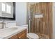 Updated bathroom featuring a sleek sink, a mirror, and wood tile in shower at 7720 W Indianola Ave, Phoenix, AZ 85033