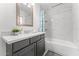 Bright bathroom featuring marble-style shower tiles, vanity with a white countertop, and a large mirror at 8044 N 10Th Pl, Phoenix, AZ 85020