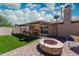 Backyard with artificial grass, paver fire pit, and covered patio creating an inviting outdoor space at 8338 E Monterosa St, Scottsdale, AZ 85251