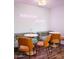 Cozy eating area features a banquette, table, and chairs, with neon sign reading 