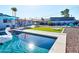 Inviting pool area featuring lounge chairs, patio dining, and artificial turf cornhole in a beautifully landscaped backyard at 8444 E Piccadilly Rd, Scottsdale, AZ 85251