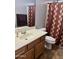Bathroom featuring a vanity with sink, toilet, and a shower with patterned curtain at 9108 W Kirby Ave, Tolleson, AZ 85353