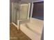 Bathroom featuring a tub with tile surround next to a shower, providing options for relaxation and convenience at 9108 W Kirby Ave, Tolleson, AZ 85353