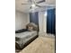 Comfortable bedroom with a ceiling fan, a large bed, and a window with blue curtains at 9108 W Kirby Ave, Tolleson, AZ 85353